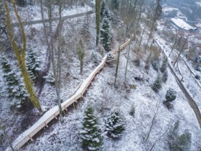 Wooden path winds through a snow-covered forest slope with trees, New wooden walkway in Calw city