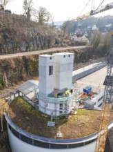 Construction site with two large concrete towers and a crane in an urban environment, extension of