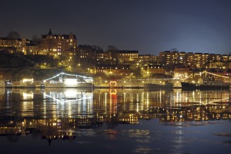 Night skyline with lights and reflections on the water, winter, ice, capital city, Södermalm,