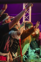 People in costumes celebrate at an event with colourful lights, carnival, Schlagerkuchen Donzdorf,