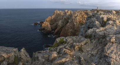 The tip of Pen Hir. The rocks are jagged and rough, the water is calm. The scenery is peaceful.