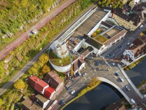 Aerial view of an urban environment with construction projects, nearby roads and a river, elevation