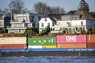 Container cargo ship on the Rhine near Düsseldorf-Bockum, villas on the banks of the Rhine, the