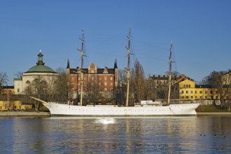 Large sailing ship in the water against an urban backdrop and clear sky, Chapman, Stockholm,