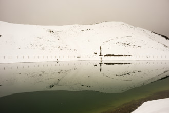 After snowfall in May: Riezler Alpsee, an artificial lake, snow pond, feeds the snow cannons that