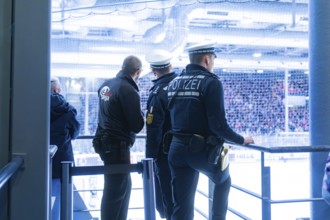 Three police officers monitor the action in an ice hockey stadium, Heilbronner Falken Vs