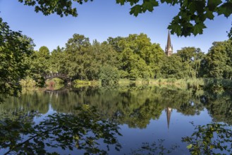 Wooden bridge in the Johannapark park and the Luther Church in Leipzig, Saxony, Germany, Europe