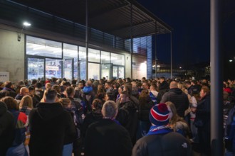 People crowd in front of the entrance of an arena at night, Heilbronner Falken Vs Bietigheimer