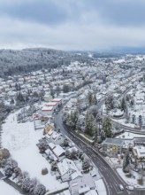 Winter village from the air with snow-covered streets and buildings surrounded by hills, Aidlingen,