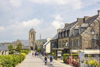 Old town Locronan with tourist walking on the street by the old houses and the old church,