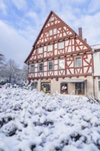 Beautiful half-timbered house in winter against a blue sky, Aidlingen, Böblingen district, Germany,