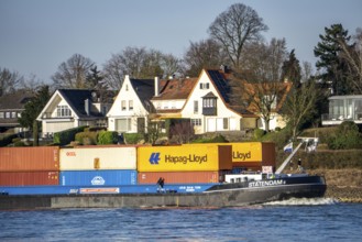 Container cargo ship on the Rhine near Düsseldorf-Bockum, villas on the banks of the Rhine, the