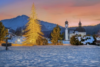 Seekirchl with artificially illuminated winter fir tree and Hocheder 2797m at dusk in winter,