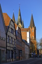 Houses on the street with the church tower of St Martin, Sendenhorst, Münsterland, North