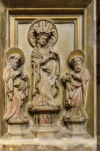 Stone relief of a group of three, Mary with baby Jesus flanked by two apostles, Church of St