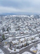 Dense cityscape in winter atmosphere with snow-covered roofs and streets, Aidlingen, Böblingen