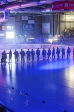 Players stand in formation on the illuminated ice surface in an arena, Heilbronner Falken Vs