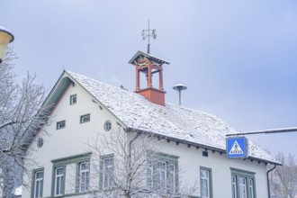 Snow-covered house with a small bell tower under a blue sky, Aidlingen, Böblingen district,