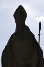 Statue of Bishop Boniface with mitre and crozier against the light, Freckenhorst, Münsterland,