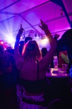 A woman dances at a lively party under colourful lighting, carnival, hit cake Donzdorf, district of