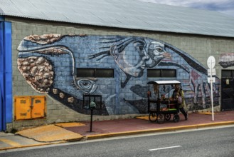 Mural with mythological whale and street vendor in the harbour of Ushuaia, Argentina, South America