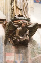 Choir hall, angel with triangle as console under the figure of a saint