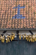 Barn with cross made of roof tiles and corn cobs