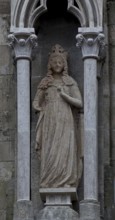 Sculpture of a crowned virgin in the left buttress canopy on the north side of the three western