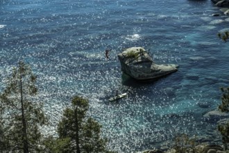 Standup paddler at Bonsai Rock, Sapphire Cove, Lake Tahoe, Nevada, USA, North America