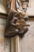 Choir hall, angel with lute as console under the figure of a saint