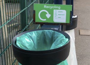 Green plastic bag in bin for recycling, UK