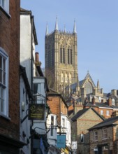 Cathedral tower rising above historic buildings, Steep Hill, Lincoln, Lincolnshire, England, UK