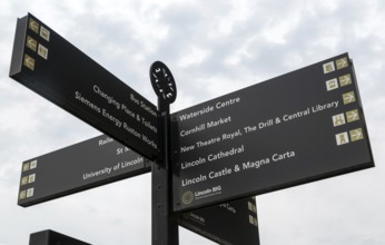 Looking up at signpost pointing to places of interest, city of Lincoln, Lincolnshire, England, UK