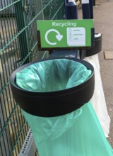 Green plastic bag in bin for recycling, UK