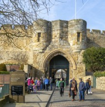 People outside entrance gateway to Lincoln castle, city of Lincoln, Lincolnshire, England, UK