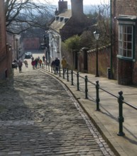 People walking up Steep Hill cobbled street, Lincoln, Lincolnshire, England, UK