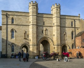 Sun shining on Exchequer Gate with horse carriage rides, Minster Yard, city of Lincoln,