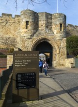 People outside entrance gateway to Lincoln castle, city of Lincoln, Lincolnshire, England, UK