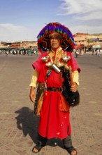 Water vendor, A man in traditional Moroccan clothing with a colourful hat stands in a square in