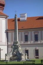 A stone monument in the form of an obelisk in front of a historic building, wachaus, donau, austria