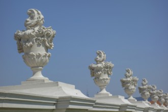 Row of artistically designed stone vases on an arcade in front of a bright blue sky, bratislava,