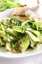 Baked Romaine lettuce with garlic and pine cores