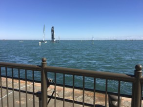 View of sailing boats on the sea behind a railing under a clear sky, chicago, illinois, usa