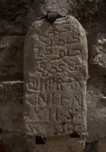 Stone with Arabic and Latin characters on a wall in the castle courtyard