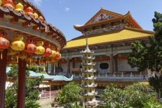 View of a temple complex with a pagoda and colourful lanterns. Embedded in lush nature, penang,