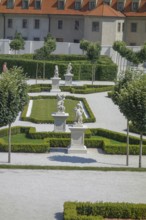 Elegant garden with ornate statues and symmetrical hedges in a baroque atmosphere, bratislava,