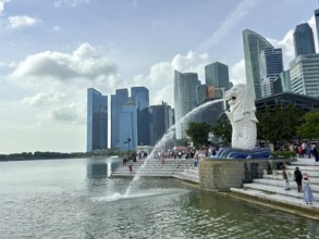 Merlion fountain spouts water in front of the impressive skyline and clouds, singapore