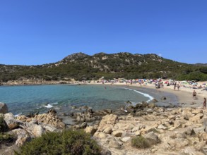 Lively beach with people and blue water, cagliari, sardinia, italy