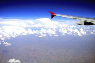 Aerial view of aeroplane wing in blue sky