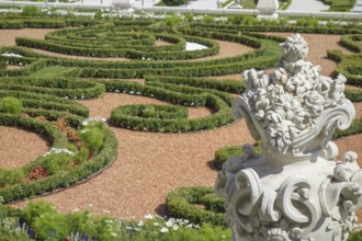 Baroque garden with creatively trimmed hedges and a decorative stone pot full of flowers,